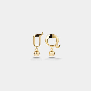Gold earrings with spherical pendants on a light gray background