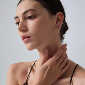 Woman wearing a gold earring with a neutral background