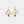 Gold earrings with diamond accents on a white background