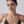 Woman wearing a brown strappy top against a plain background