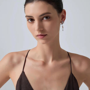 Woman wearing a brown strappy top against a plain background