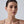 Woman wearing earrings with a plain background