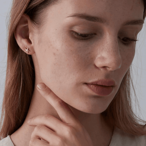 Model wearing a gold stud earring featuring starfish design