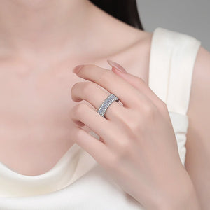 Close-up of a hand wearing a silver ring with a blurred background