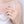 Hand wearing a silver ring on a plain background