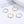 Two pairs of hoop earrings, one gold and one silver, on a magazine page.