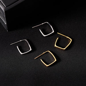 Set of gold and silver hoop earrings on a black background
