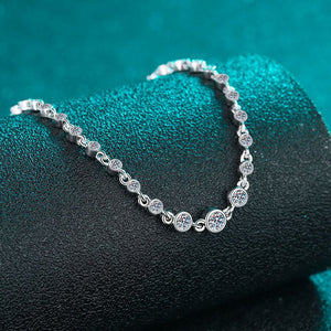 Silver bracelet with circular links on a textured green surface