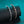 Two diamond-encrusted bracelets on a black stand with a teal background