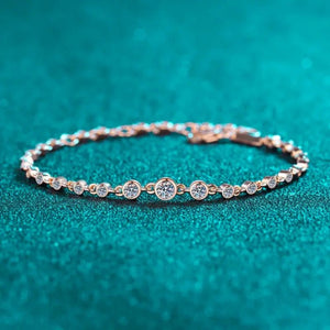 Rose gold bracelet with diamonds on a teal background