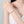 Woman's hand wearing a bracelet on a plain background