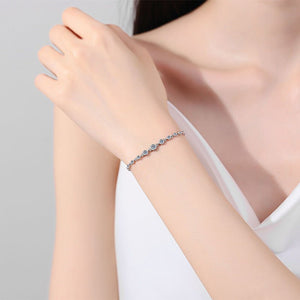 Woman's hand wearing a bracelet on a plain background