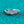 Silver ring with gemstones on a teal glittery background