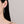 Close-up of a woman wearing diamond earrings with a plain background