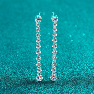 Silver chain earrings on a teal background