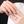 Close-up of two hands wearing silver rings with a blurred background