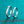 Two silver rings on a teal glittery background