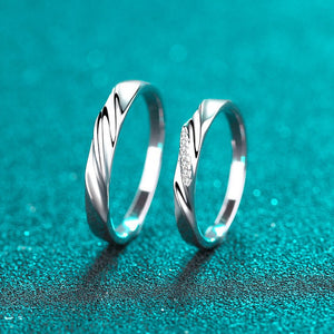 Two silver rings on a teal glittery background