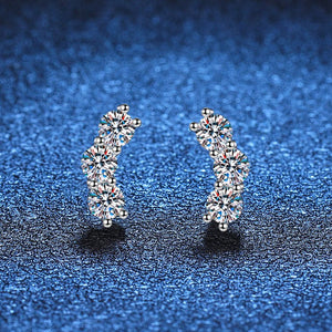 Pair of silver hoop earrings with clear gemstones on a blue textured background