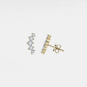 Gold earrings with clear gemstones on a light gray background
