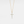 Gold cross necklace with diamonds on a light gray background