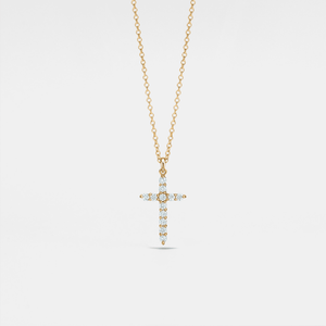 Gold cross necklace with diamonds on a light gray background