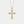 Gold cross necklace with diamonds on a light gray background