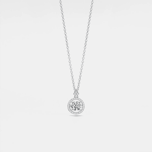 Silver necklace with a round pendant on a light gray background