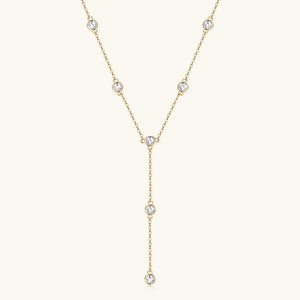 Gold necklace with small diamonds on a light beige background