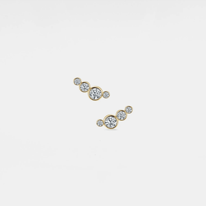 Pair of gold earrings with clear gemstones on a light gray background