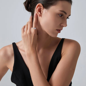 Woman wearing a diamond ring on her finger against a plain background