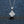 Silver necklace with a diamond pendant on a dark textured background