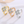 Three rings in gold, rose gold, and silver with diamond-like center stones on a white background.