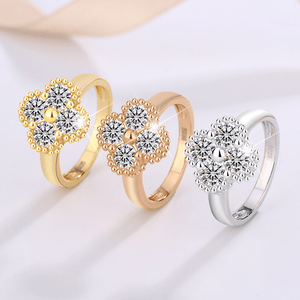 Three rings in gold, rose gold, and silver with diamond-like center stones on a white background.