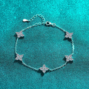 Silver bracelet with star-shaped charms on a teal background