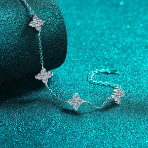 Silver bracelet with star-shaped charms on a teal background