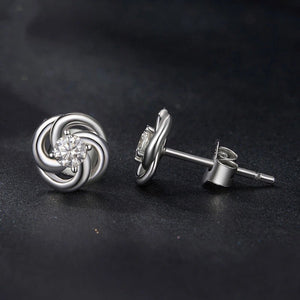 Silver earrings with a central gemstone on a dark background