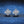 Pair of silver earrings with a star design on a blue textured background