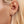 Close-up of an ear wearing a diamond stud earring with blonde hair.