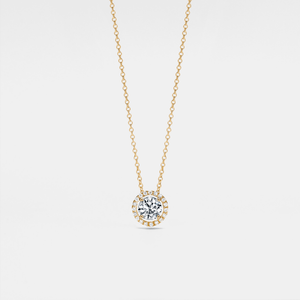 Gold necklace with a diamond pendant on a light gray background