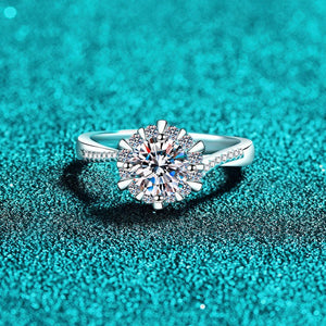 Silver ring with a large diamond on a teal glittery background