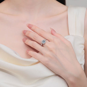 Close-up of a hand wearing a diamond ring on a white fabric background