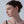 Woman wearing a diamond earring against a plain background