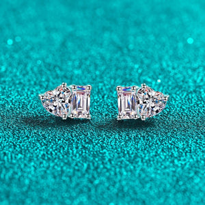 Pair of diamond earrings on a teal glitter background