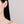 Close-up of a person wearing a diamond earring on a neutral background
