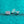 Two silver earrings on a teal glittery background