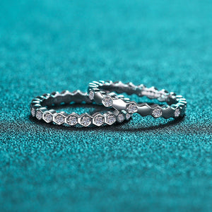 Two silver rings with diamond accents on a teal background