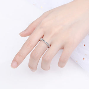 Hand wearing a silver ring on a white background