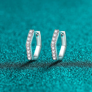 Pair of silver hoop earrings with small diamonds on a teal textured background