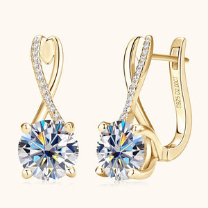 Gold earrings with large gemstones on a white background
